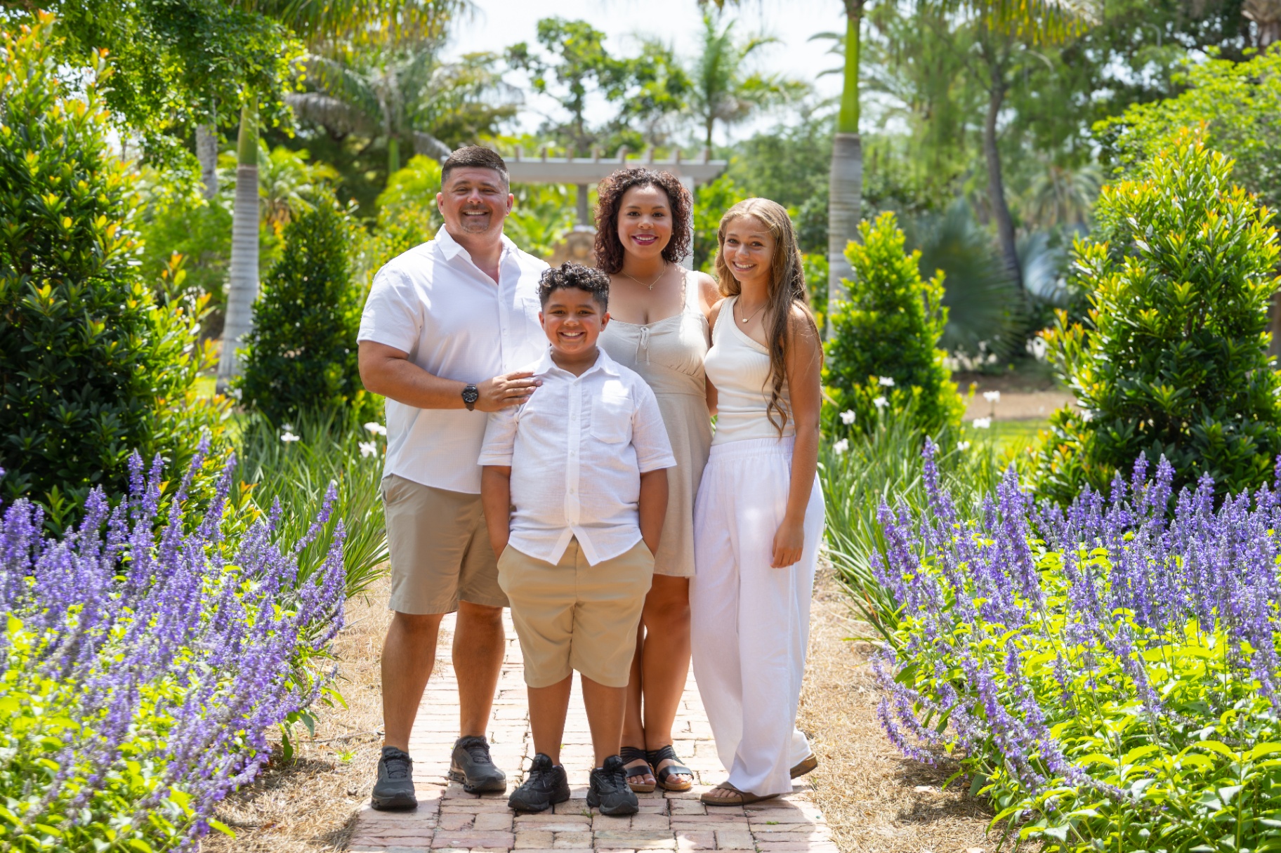 A family standing together in a sunlit tropical garden